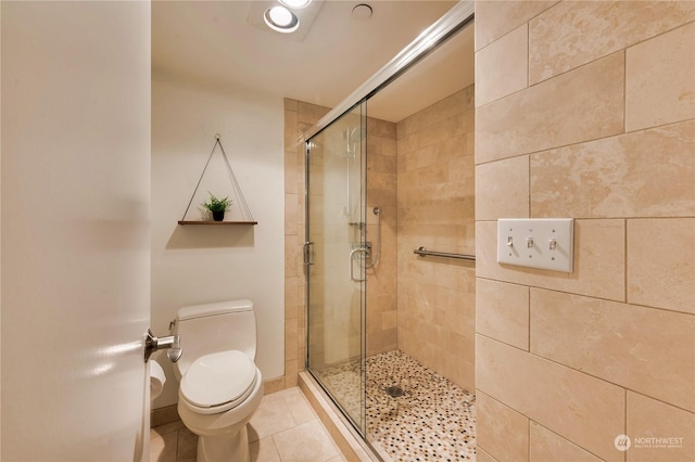 bathroom featuring toilet, tile patterned floors, and an enclosed shower