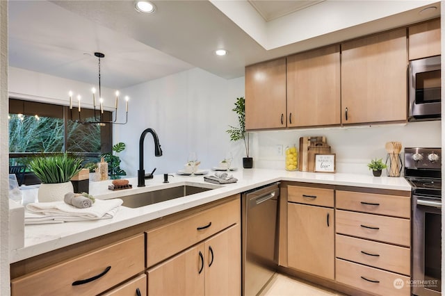 kitchen featuring decorative light fixtures, stainless steel appliances, light brown cabinetry, sink, and a chandelier