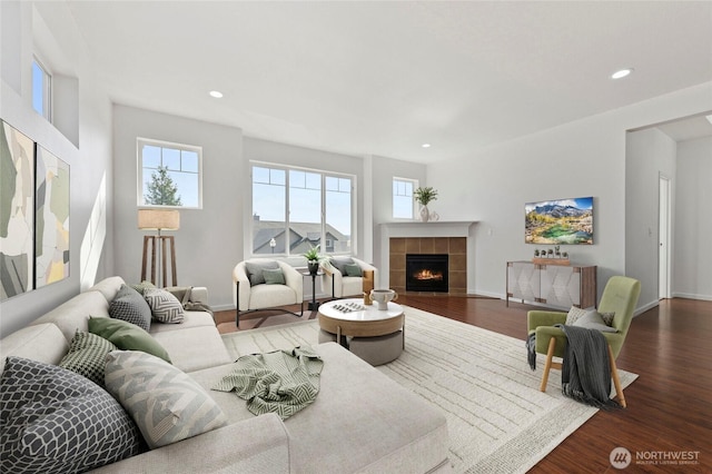 living room with baseboards, recessed lighting, dark wood-style flooring, and a tile fireplace