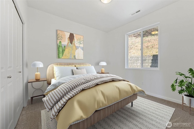 bedroom featuring a closet, visible vents, baseboards, and carpet floors