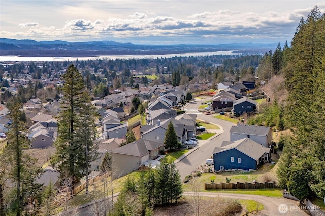 aerial view with a residential view, a mountain view, and a view of trees