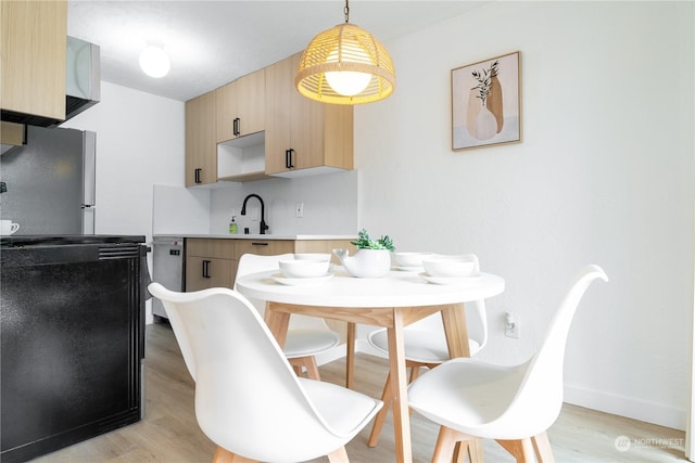 dining room featuring light wood-type flooring and sink