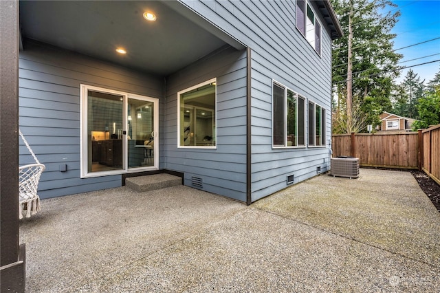 view of side of home with central AC unit and a patio