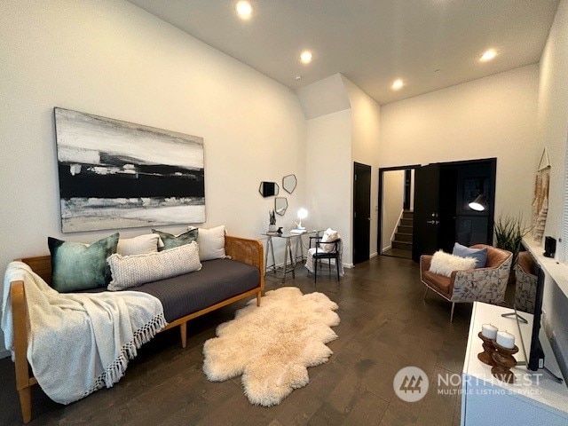 living room featuring a high ceiling and dark wood-type flooring