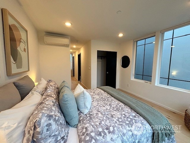 bedroom featuring an AC wall unit and a closet