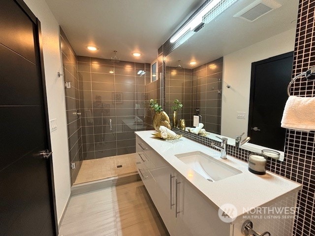 bathroom with walk in shower, tile patterned floors, and vanity