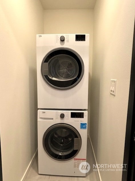 washroom featuring light tile patterned floors and stacked washer / dryer