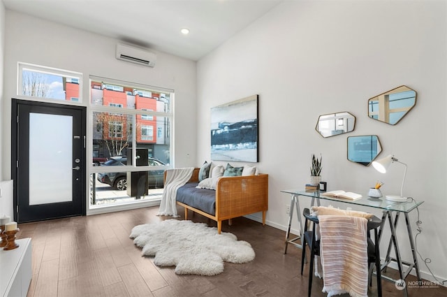 sitting room featuring an AC wall unit and dark hardwood / wood-style flooring