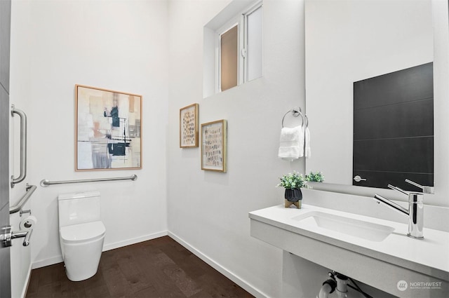 bathroom with sink, toilet, and wood-type flooring