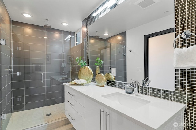 bathroom featuring vanity, walk in shower, and tile walls