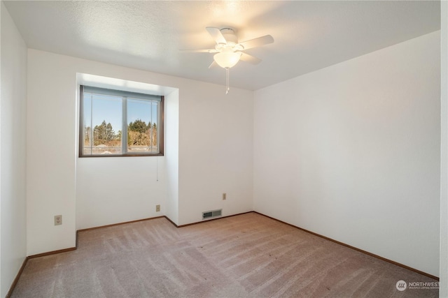 carpeted spare room featuring a textured ceiling and ceiling fan