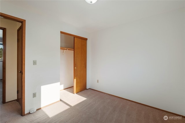 unfurnished bedroom with a closet and light carpet