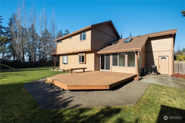 rear view of house with a yard and a deck