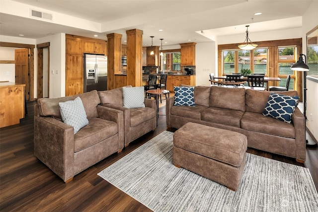 living room with decorative columns and dark hardwood / wood-style flooring