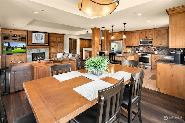 tiled dining space featuring a raised ceiling and sink