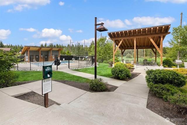 view of community featuring a pool, a gazebo, a patio, and a yard