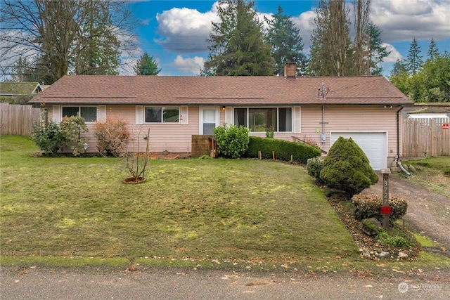 ranch-style home with a garage and a front yard