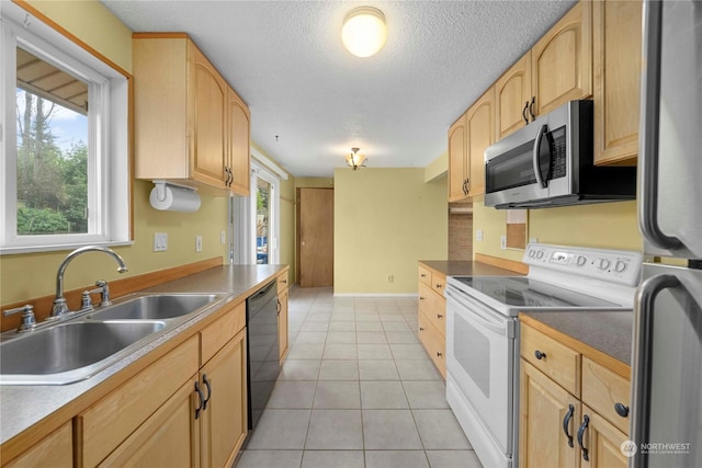 kitchen with plenty of natural light, sink, stainless steel appliances, and light tile patterned flooring