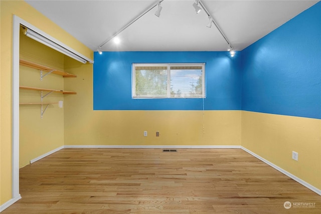 spare room featuring track lighting and light wood-type flooring