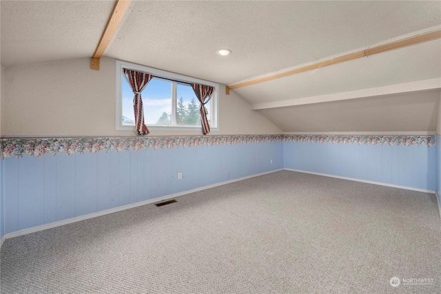 bonus room featuring a textured ceiling, carpet, and vaulted ceiling with beams