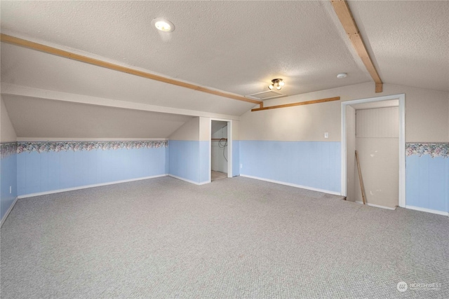 bonus room featuring a textured ceiling, carpet, and lofted ceiling with beams