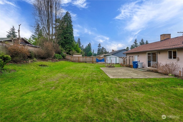 view of yard with a storage shed and a patio