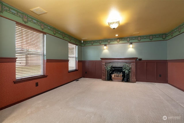 unfurnished living room featuring a tiled fireplace and carpet