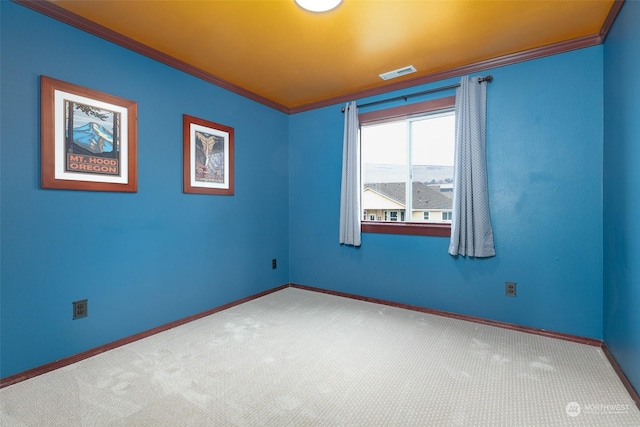 carpeted empty room featuring crown molding