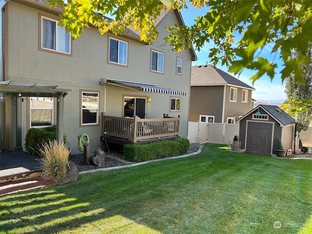 back of house with a yard, a wooden deck, and a storage shed