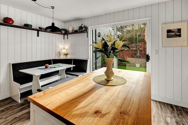 dining room with wooden walls and hardwood / wood-style flooring