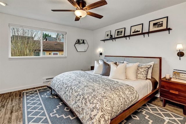 bedroom featuring hardwood / wood-style floors, a baseboard radiator, and ceiling fan