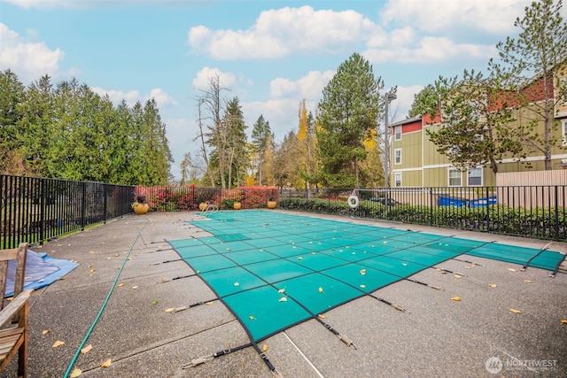 view of swimming pool featuring a patio area, fence, and a fenced in pool