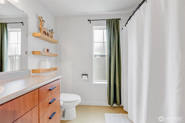 bathroom with toilet, baseboards, vanity, and a shower with curtain