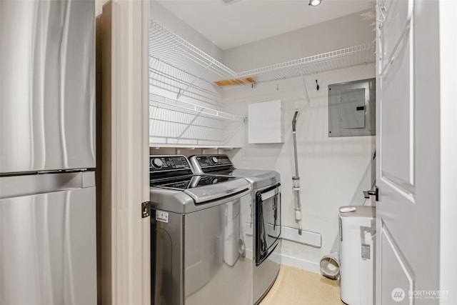 clothes washing area with laundry area, electric panel, and independent washer and dryer