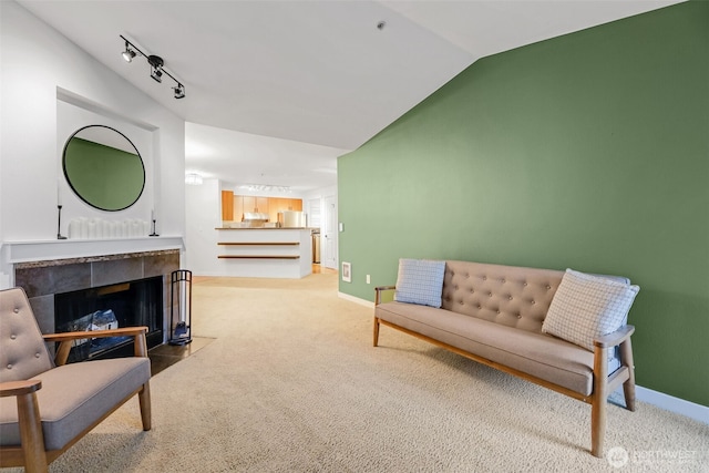 interior space with lofted ceiling, track lighting, baseboards, and light colored carpet