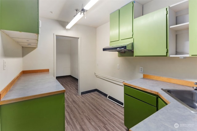 kitchen with sink, green cabinets, and light wood-type flooring