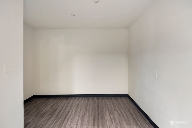 unfurnished room featuring dark wood-type flooring