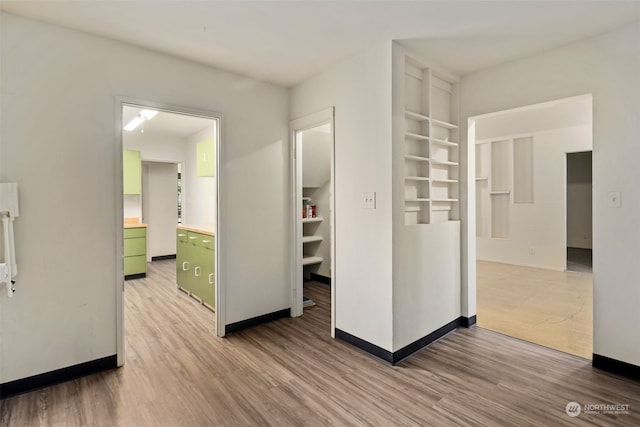 corridor with hardwood / wood-style floors and built in features