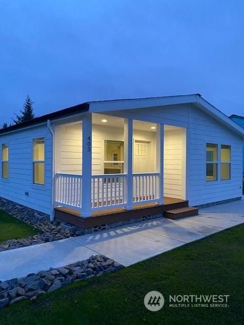 view of home's exterior with a lawn and covered porch