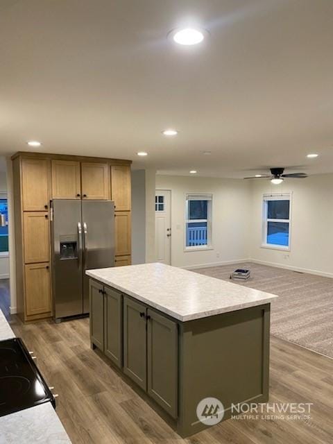 kitchen with ceiling fan, light hardwood / wood-style floors, stainless steel fridge with ice dispenser, a kitchen island, and electric range