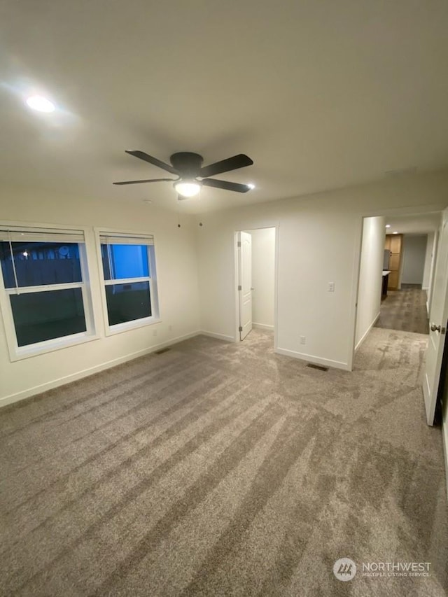 carpeted empty room featuring ceiling fan