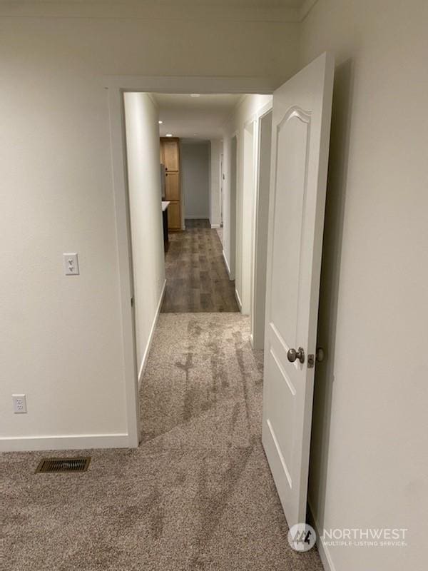 hall featuring dark colored carpet