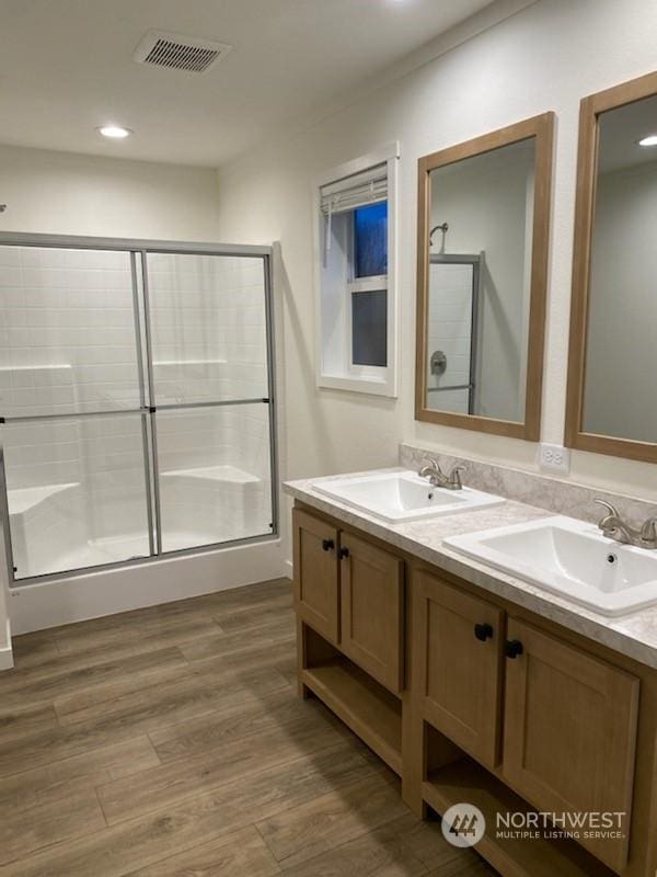 bathroom with vanity, wood-type flooring, and walk in shower