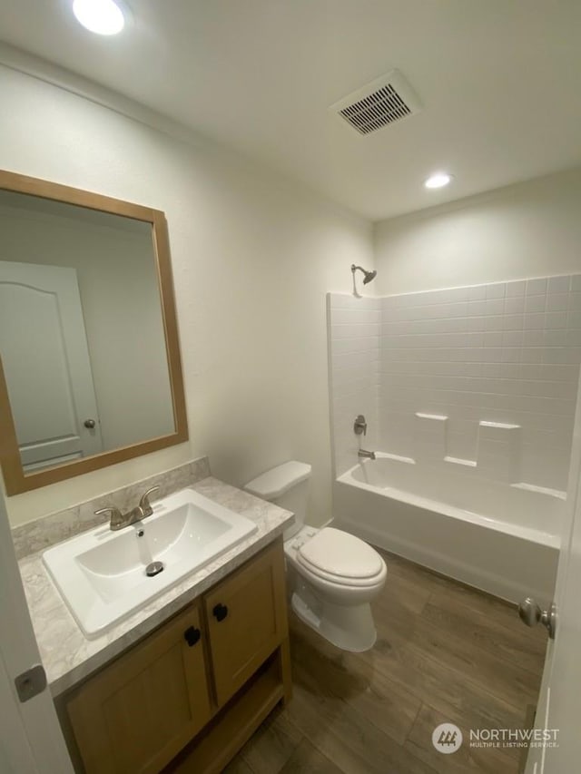 full bathroom with toilet, hardwood / wood-style flooring,  shower combination, and vanity