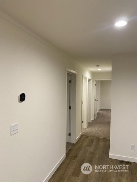 hallway featuring ornamental molding and dark hardwood / wood-style floors