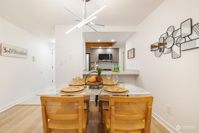 dining space with a chandelier and light hardwood / wood-style flooring