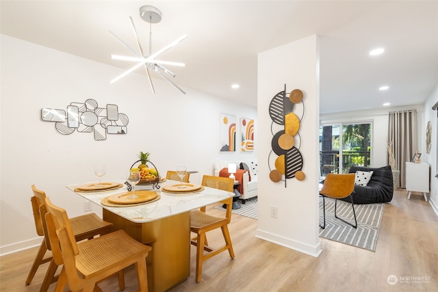 dining space featuring light hardwood / wood-style floors and a notable chandelier