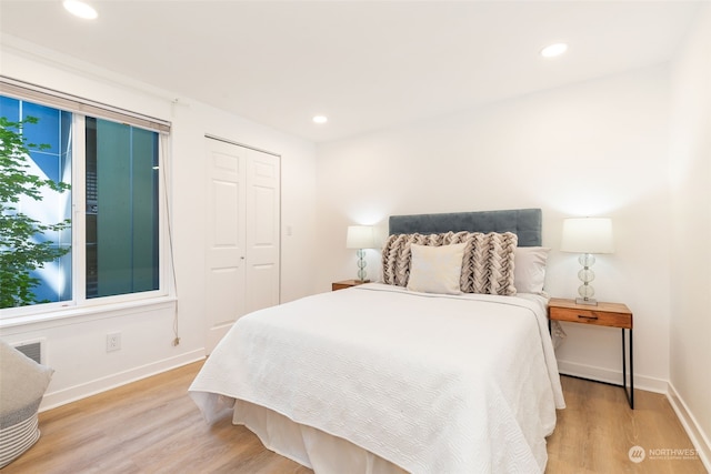 bedroom with light hardwood / wood-style floors and a closet