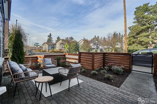 view of patio with outdoor lounge area, fence, and a gate