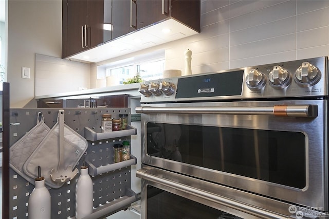 details with stainless steel double oven, backsplash, and dark brown cabinets